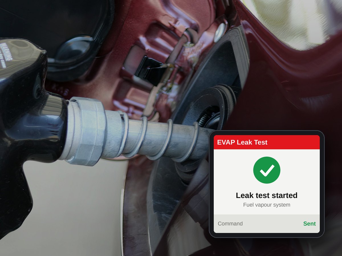 Pistola del carburante nel bocchettone di un’auto, con un test perdite EVAP avviato sullo schermo dello scanner